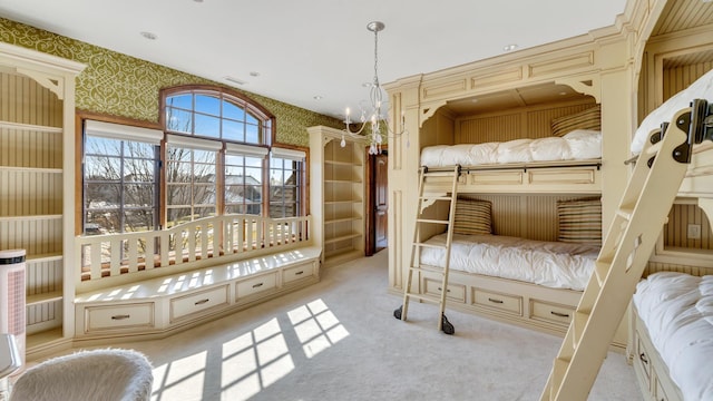 unfurnished bedroom with wallpapered walls, an inviting chandelier, carpet flooring, and visible vents