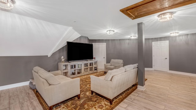 living area featuring light wood-type flooring, baseboards, and vaulted ceiling