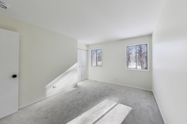 empty room with light carpet and baseboards