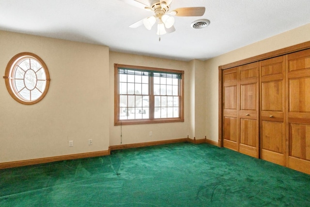 unfurnished bedroom with dark colored carpet, ceiling fan, and a closet