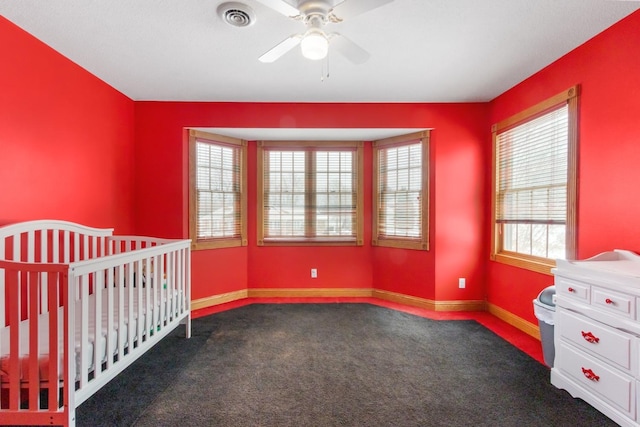 unfurnished bedroom with dark carpet and ceiling fan