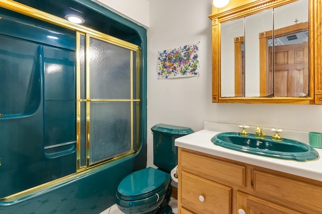 full bathroom featuring vanity, combined bath / shower with glass door, and toilet