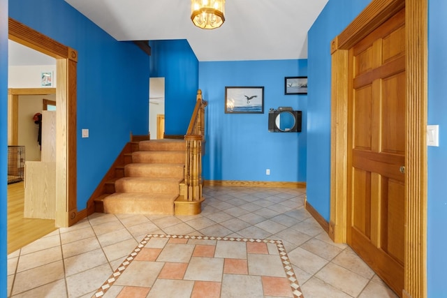 staircase featuring an inviting chandelier and tile patterned floors