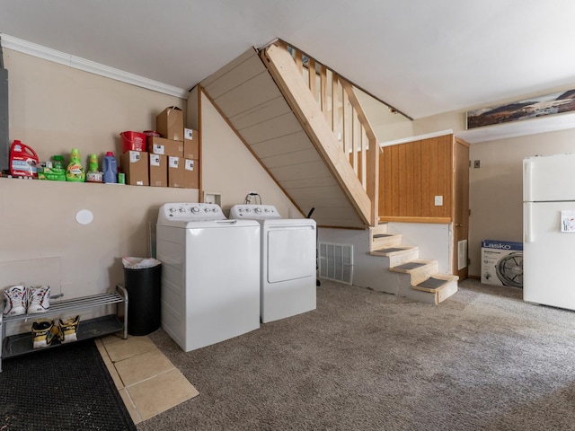 laundry room with ornamental molding, washing machine and dryer, and carpet flooring