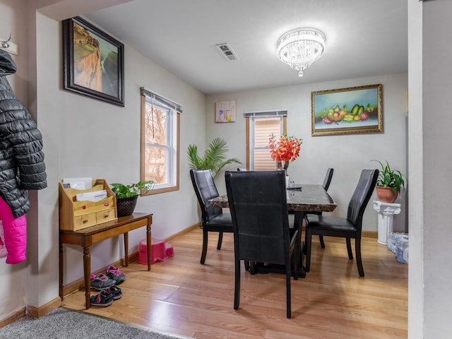 dining room with hardwood / wood-style floors and a notable chandelier