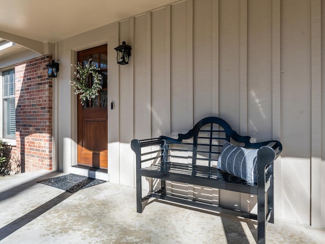 view of exterior entry featuring brick siding and board and batten siding