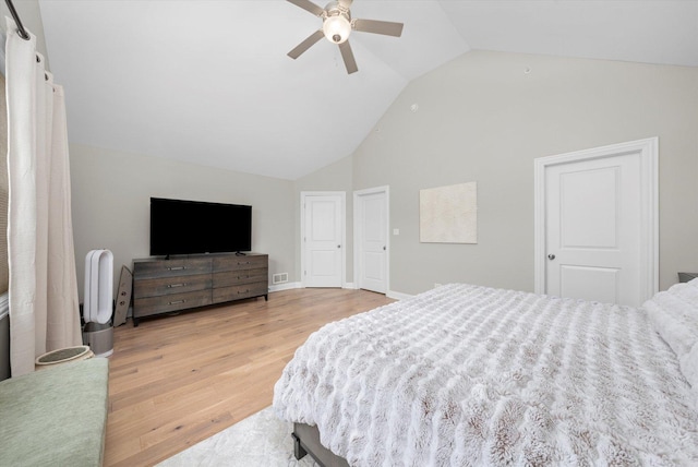 bedroom featuring visible vents, light wood-style flooring, ceiling fan, high vaulted ceiling, and baseboards