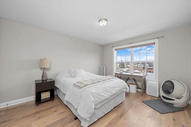 bedroom with light wood-type flooring and baseboards