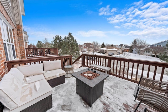 snow covered deck with a residential view and an outdoor living space with a fire pit