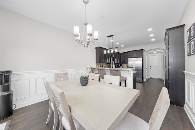 dining area featuring dark wood-style floors, a wainscoted wall, a chandelier, and recessed lighting