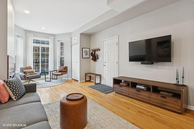 living room with baseboards, wood finished floors, and recessed lighting