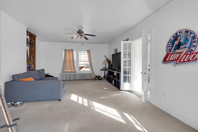 living area with carpet, ceiling fan, and radiator heating unit