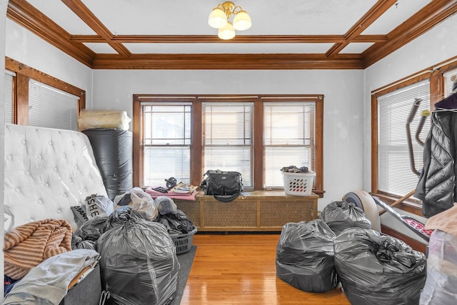 interior space with ornamental molding, coffered ceiling, and wood finished floors