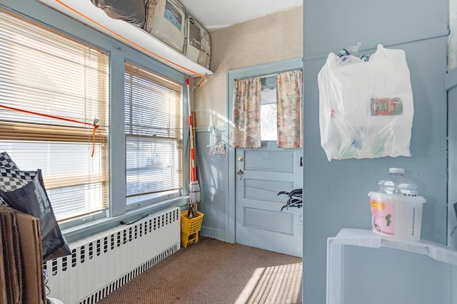 doorway to outside with carpet floors and radiator