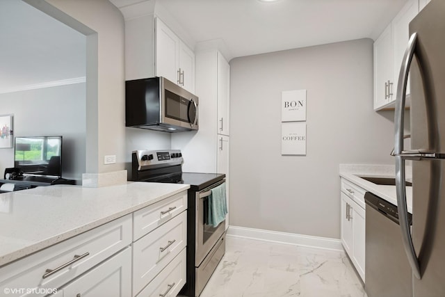 kitchen featuring light stone counters, marble finish floor, appliances with stainless steel finishes, white cabinets, and baseboards