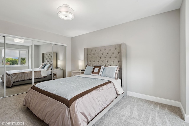 bedroom featuring baseboards, a closet, and light colored carpet