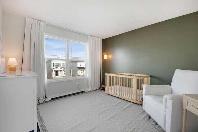 carpeted bedroom featuring a nursery area and radiator