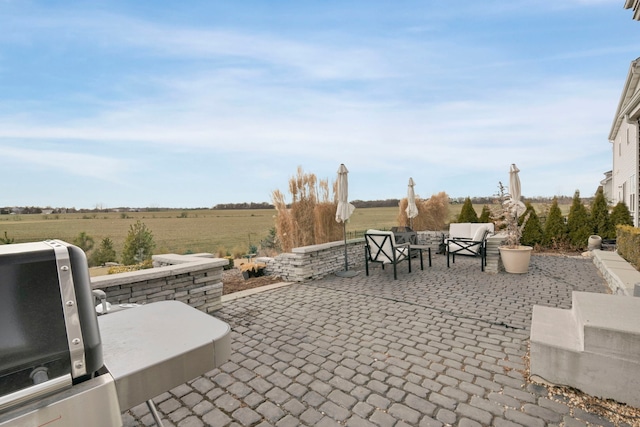 view of patio / terrace featuring an outdoor living space and a rural view