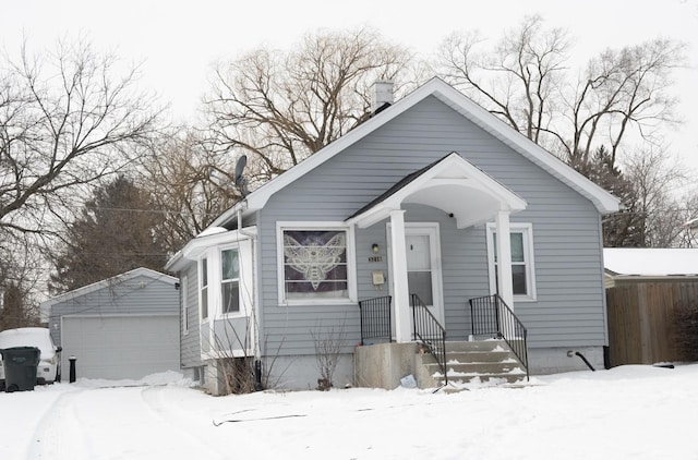 bungalow with a garage and an outdoor structure