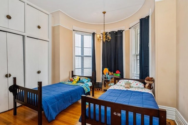 420 N Marion St, Oak Park, IL 60302 - bedroom featuring baseboards, an inviting chandelier, and light wood-style floors