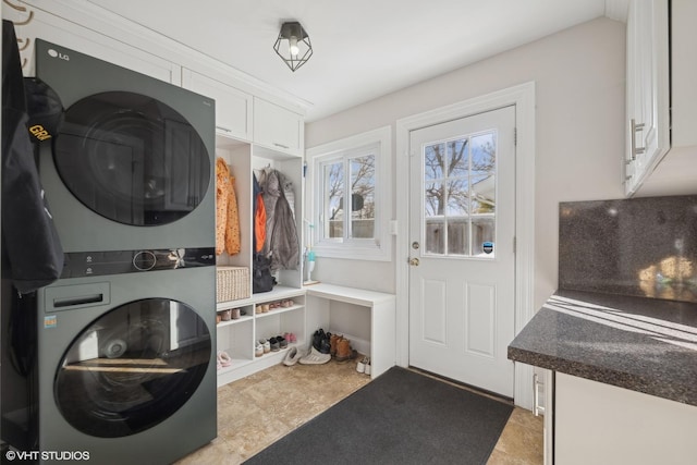 clothes washing area featuring laundry area and stacked washer and clothes dryer