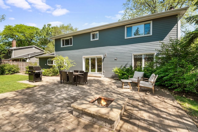 rear view of property with an outdoor fire pit, a patio area, and fence