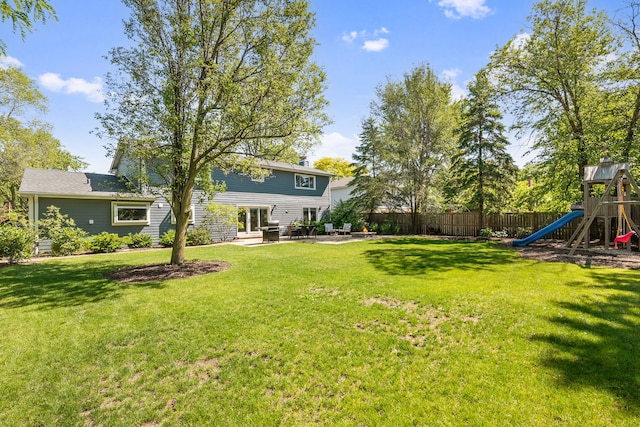 view of yard with a patio, a playground, and fence