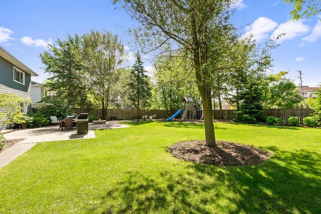 view of yard with a patio area, a playground, and a fenced backyard