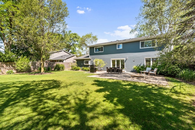 back of property with a patio area, a fenced backyard, and a lawn