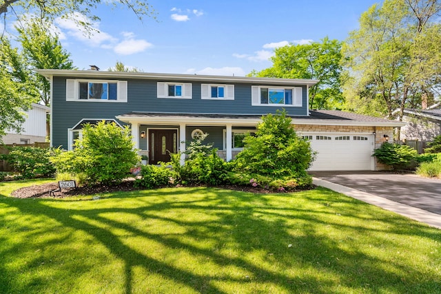 view of front of property featuring a garage, driveway, and a front yard