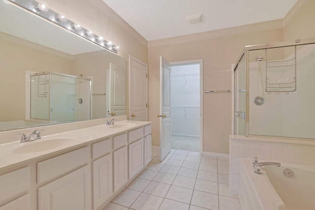 bathroom featuring double vanity, a stall shower, a sink, and tile patterned floors