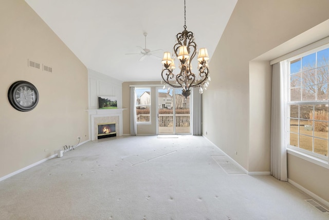 unfurnished living room with light carpet, high vaulted ceiling, a glass covered fireplace, and visible vents