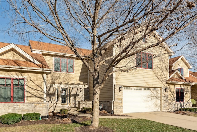 view of front of property with a garage, stone siding, and driveway