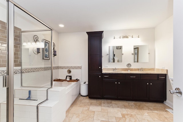 bathroom featuring double vanity, a garden tub, a sink, and recessed lighting