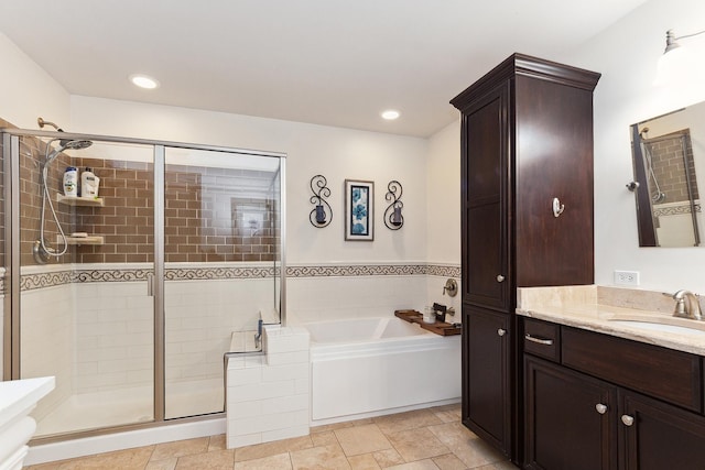 full bathroom featuring vanity, a shower stall, a bath, and recessed lighting