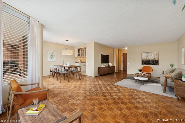 living room featuring dark parquet flooring and a textured ceiling