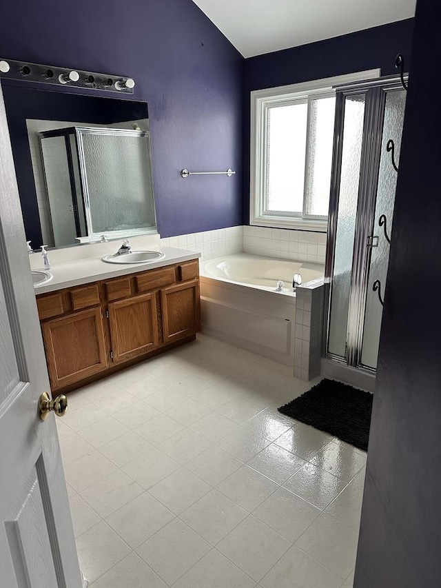 bathroom with plus walk in shower, vanity, and tile patterned flooring