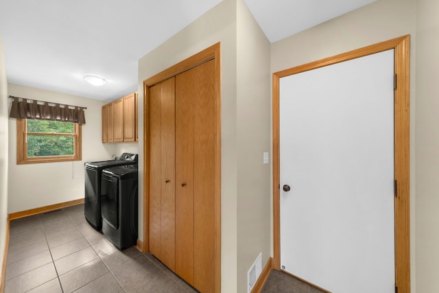 laundry area with light tile patterned floors, separate washer and dryer, and cabinets