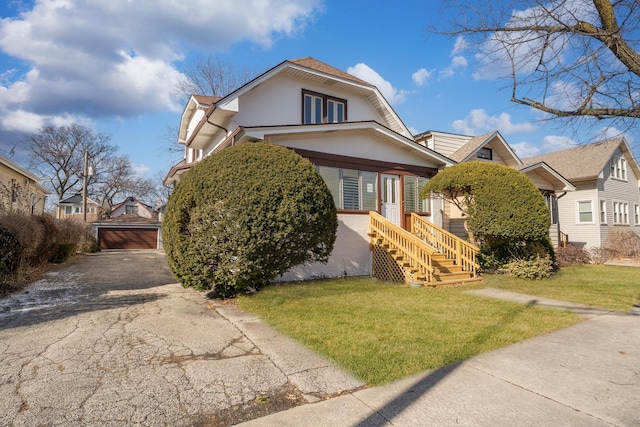 view of front facade featuring an outbuilding, a front yard, and a garage