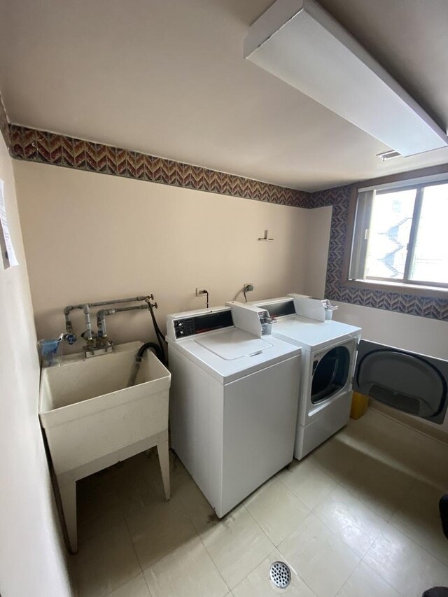 clothes washing area with a sink and washing machine and clothes dryer