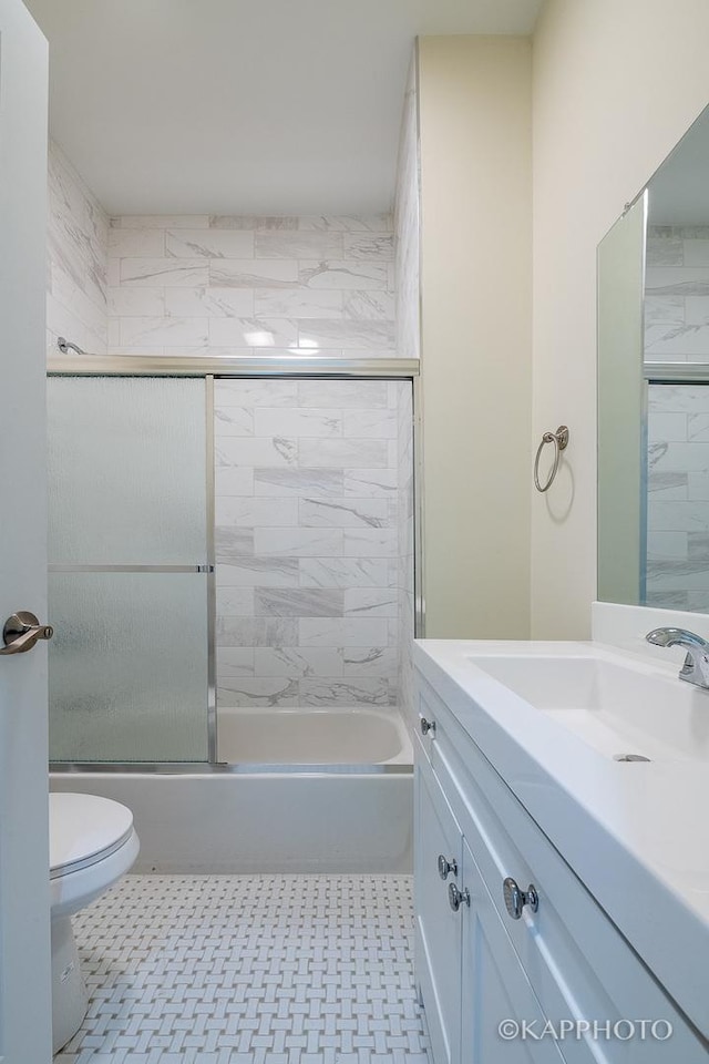 full bathroom with toilet, vanity, and shower / bath combination with glass door