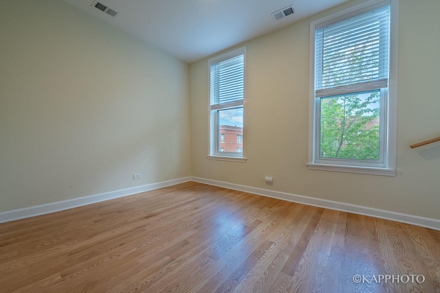 spare room with vaulted ceiling and light hardwood / wood-style flooring