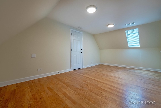 additional living space featuring lofted ceiling and light wood-type flooring