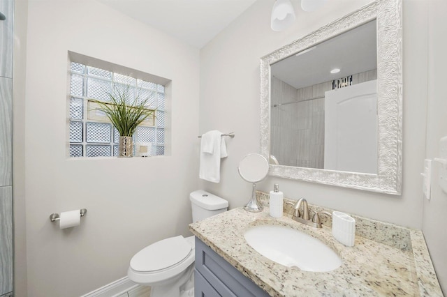 bathroom with vanity, toilet, and a shower