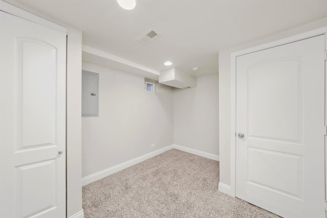 basement featuring light carpet and electric panel