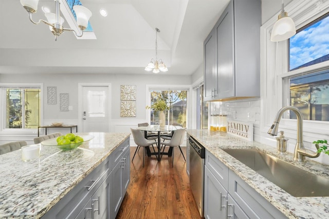 kitchen featuring sink, gray cabinets, dishwasher, hanging light fixtures, and a chandelier