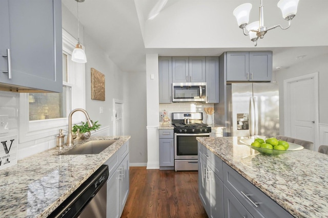 kitchen featuring appliances with stainless steel finishes, decorative light fixtures, gray cabinets, and sink