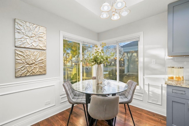 dining room with dark hardwood / wood-style flooring and a chandelier