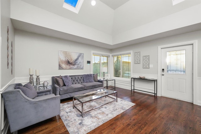 living room with dark wood-type flooring and a skylight