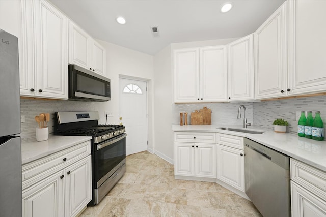 kitchen with stainless steel appliances, white cabinets, light countertops, and a sink